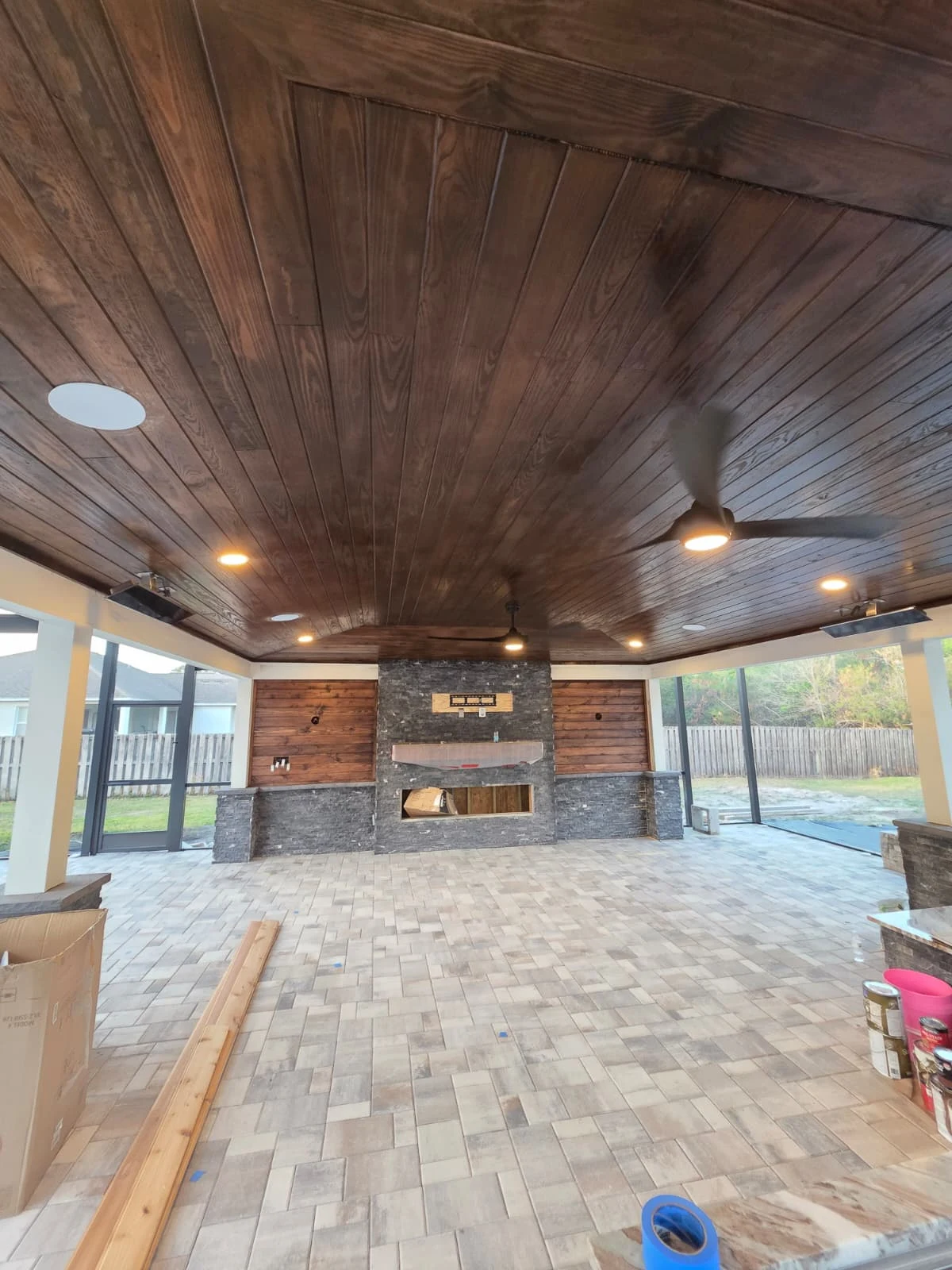 Custom-built outdoor living area featuring premium wood ceiling details, tile flooring and luxury finishes