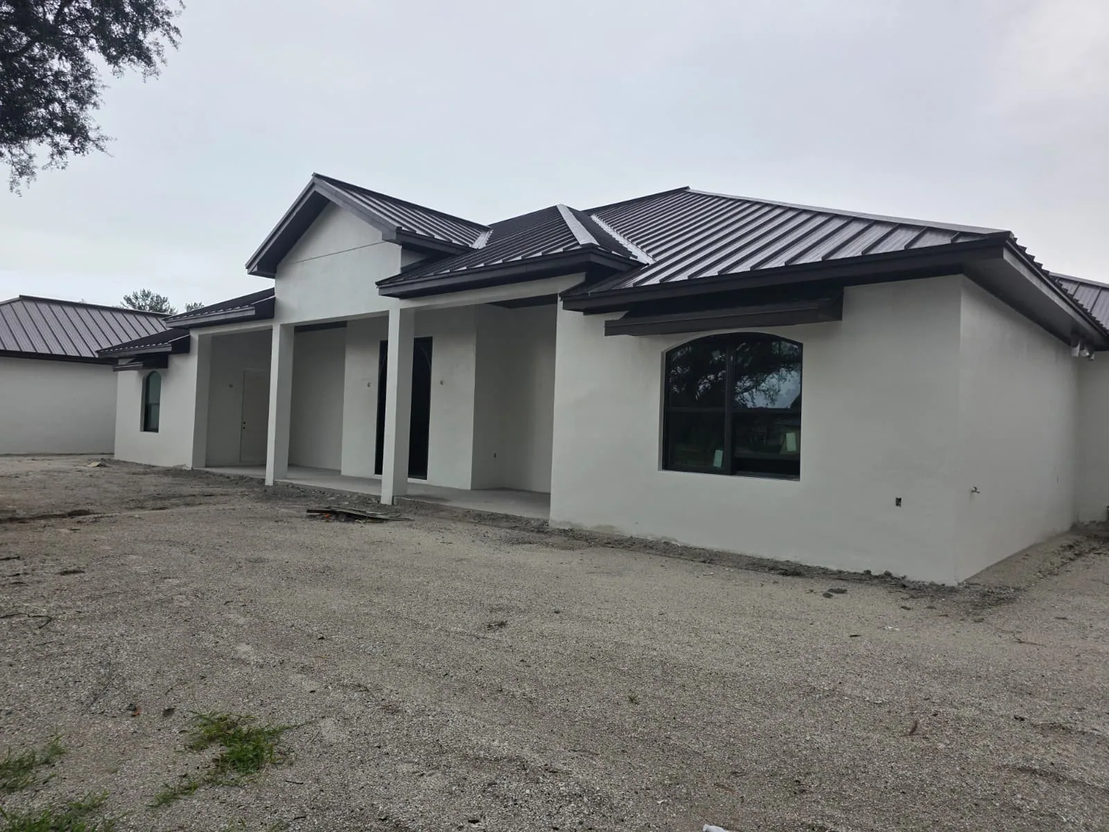 Finished stucco exterior with metal roof on a custom home in Central Florida